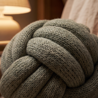 Close-up of the sage knit knot pillow where the knitted tubes cross over