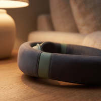 Close-up of the cordless neck massager's sage contact pad on its charcoal arm