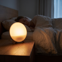 Sunrise wake-up light glowing on a nightstand before dawn