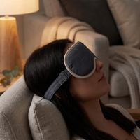 Woman reclining on a sofa wearing the heated eye massager